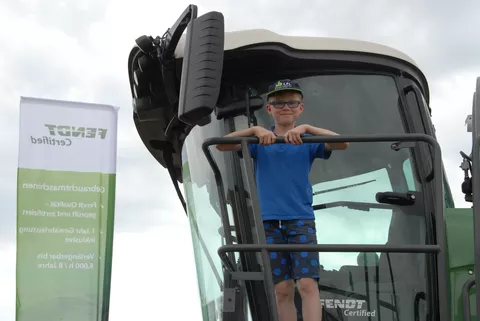 Lächelnd blickt ein kleiner Junge von der Fahrerkabine