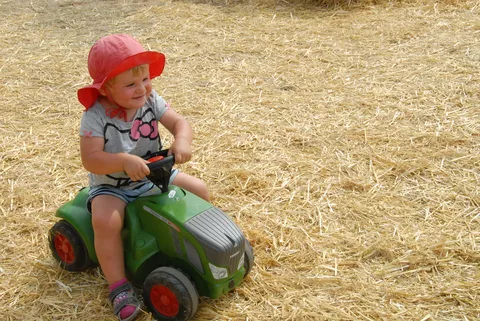 Kleines Mädchen sitzt auf einem Fendt Bobbycar