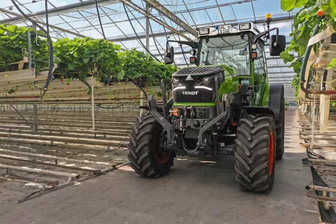 Der Fendt e100 Vario steht in einem Gewächshaus mit Erdbeerkulturen