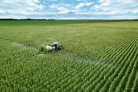 Fendt Rogator 900 beim spritzen von einem Maisfeld von hinten