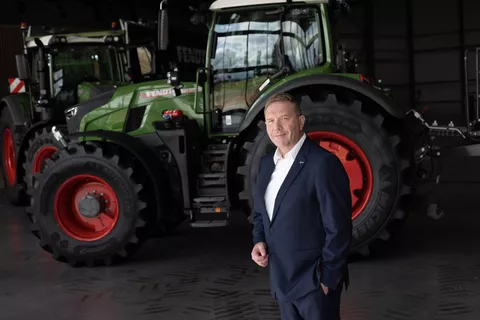 Christoph Gröblinghoff, Vorsitzender der Fendt Geschäftsführung, im Anzug vor einem Fendt Traktor