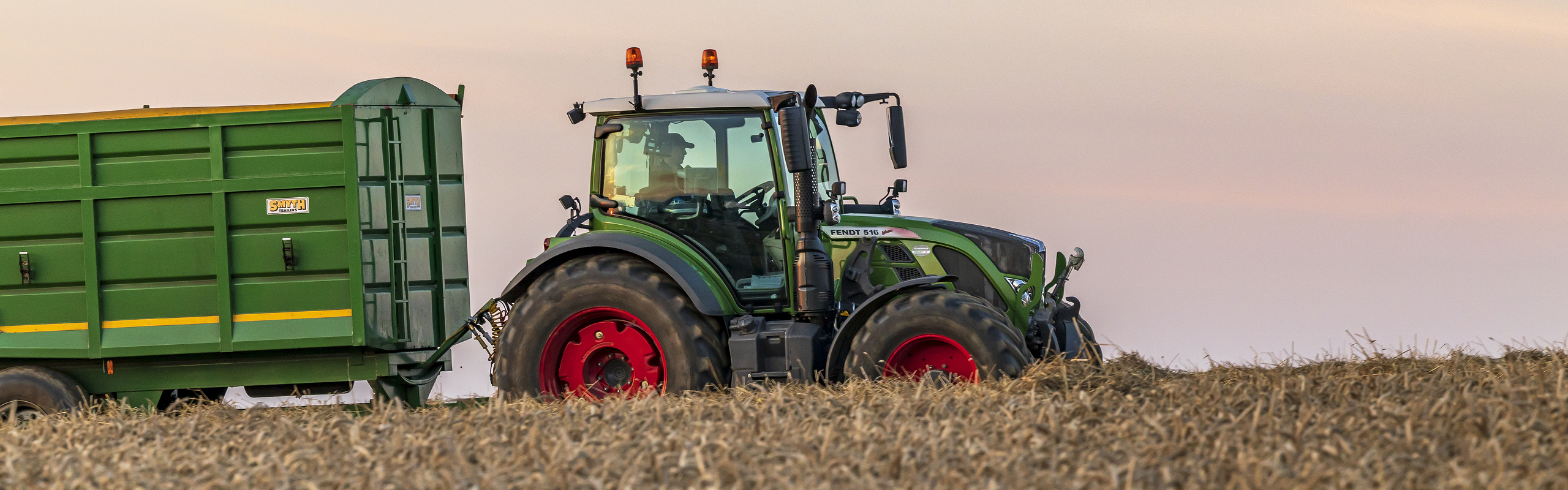 Ein schwarzer IDEAL Mähdrescher auf dem Hof eines Händlers mit einem Fendt Profi im Vordergrund