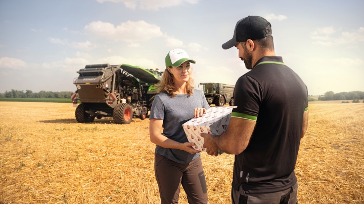 Ein Fendt Servicemitarbeiter liefert Ersatzteile direkt am Hof einer Landwirtin aus