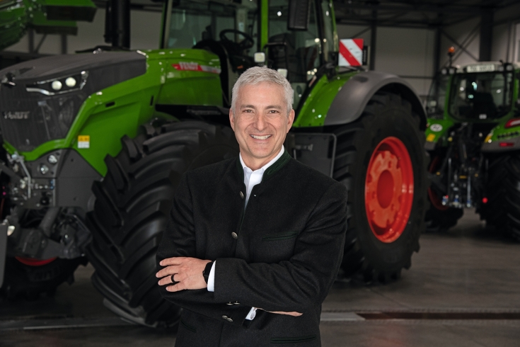 Portrait von Eric Hansotia, CEO AGCO Corporation im Anzug vor einem Fendt Traktor