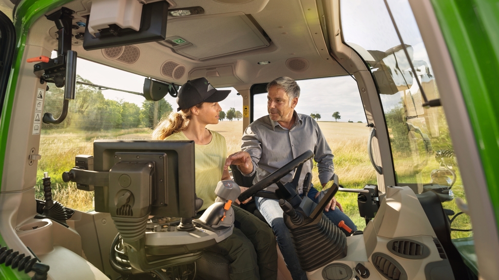 Ein Fendt Händler weist eine Landwirtin in den Fendt Traktor 700 Vario ein