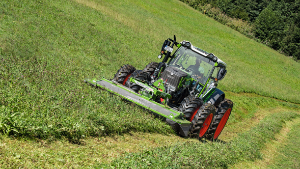 Fendt Traktor mit Fendt Slicer Frontanbau beim Mähen am Hang.