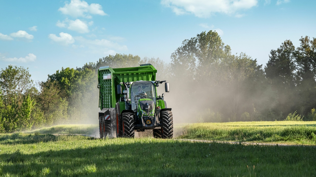 Ein Fendt 700 Vario Gen6 mit angehängtem Tigo Ladewagen auf dem Weg zur Wiese