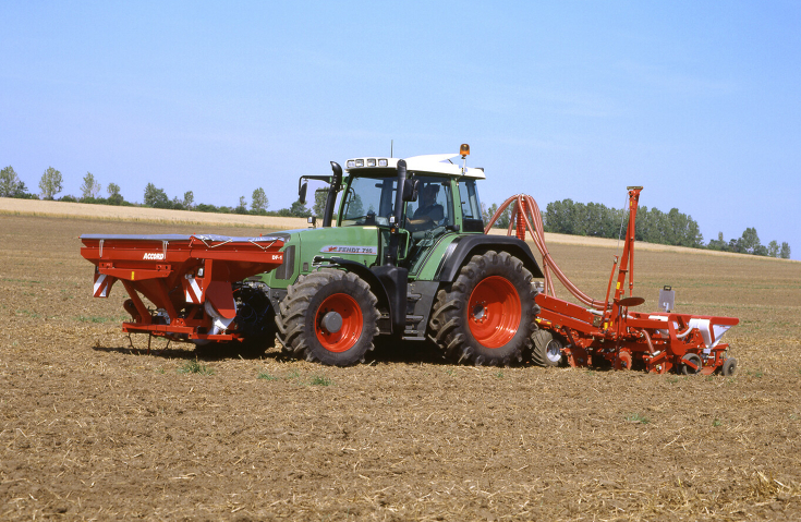 Fendt 716 Vario Gen3 bei der Aussaat mit einer roten Sämaschine