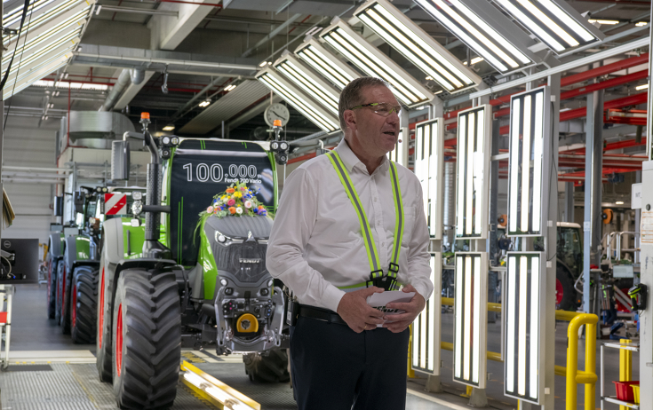 Christoph Gröblinghoff, Vorsitzender der Fendt Geschäftsführung, steht vor dem mit Blumen geschmückten Fendt 728 Vario am Lichttunnel in Marktoberdorf