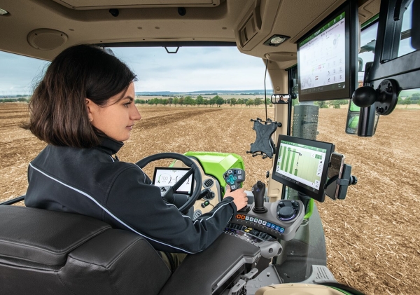 Eine Landwirtin in der Traktor Fahrerkabine bei der Nutzung von FendtONE onboard