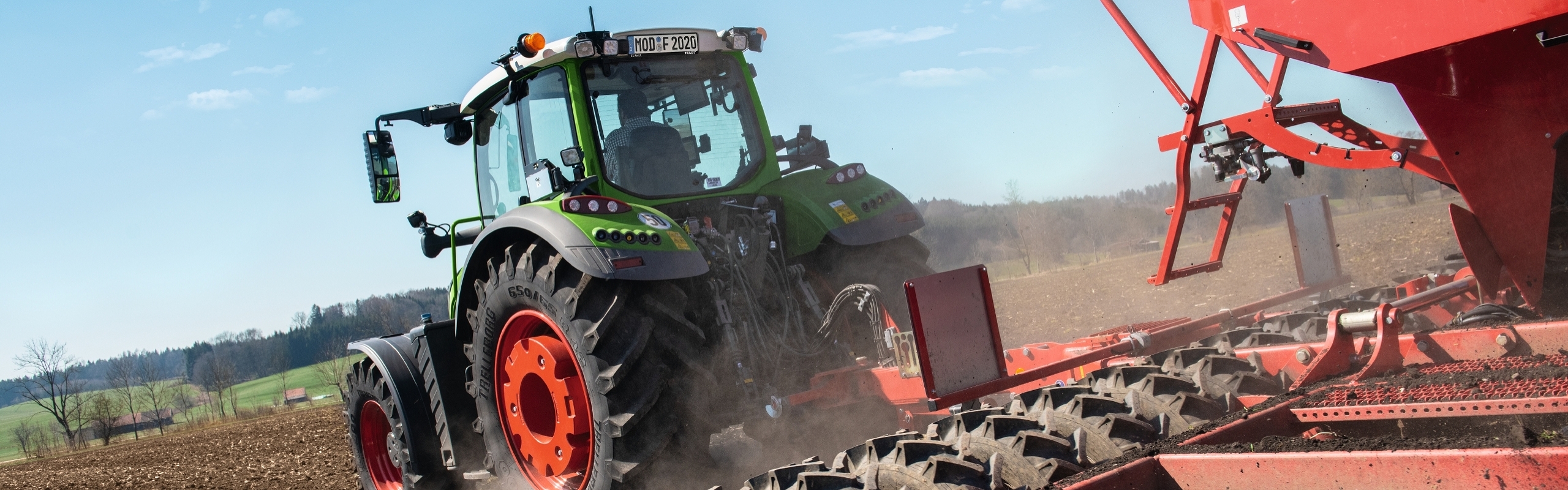 Ein Landwirt fährt mit einem Fendt 700 Vario Gen6 und einer Horsch Drillmaschine auf dem staubigen Acker.