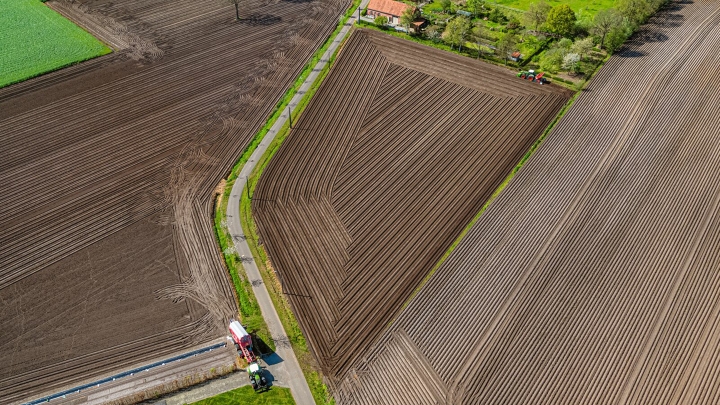 Luftansicht eines Feldes mit zwei grünen Fendt Traktoren bei der Bodenbearbeitung mit FendtONE Spurführung