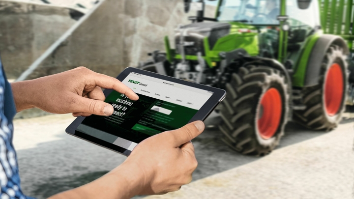 Landwirt mit Tablett in der Hand und der Ansicht zur FendtONE Telemetrie