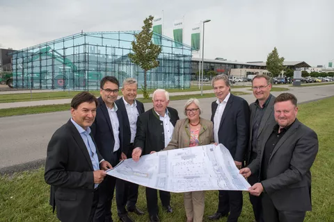 People with building plans in front of the future Fendt Forum