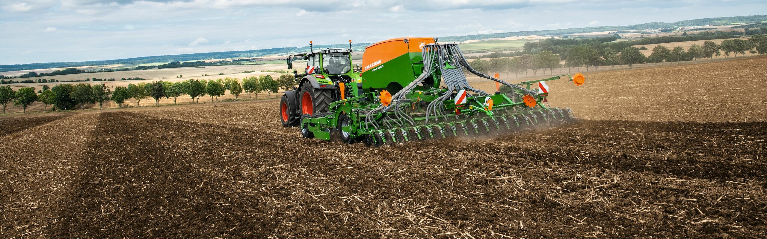 A Fendt tractor in the field using implement guidance for soil cultivation