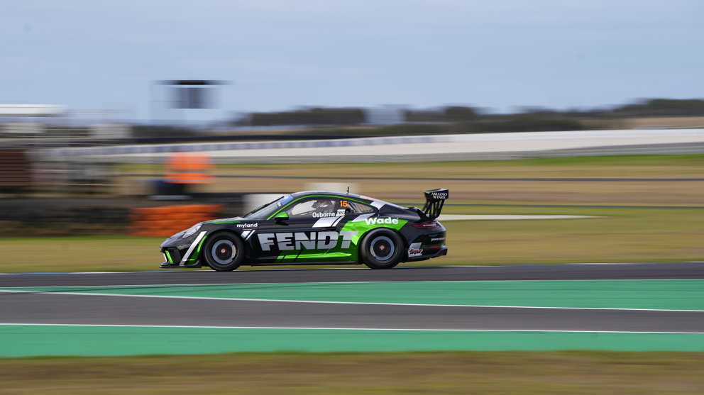 Clay Osborne on the race track with his Porsche racing car showing the green Fendt logo on the side