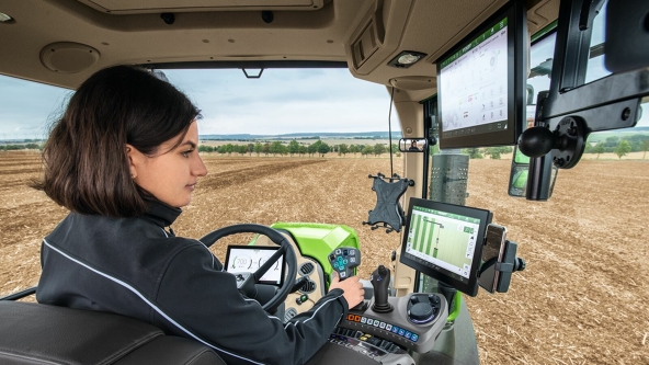 A farmer in the cab of her Fendt tractor using the Smart Farming solution Teach-In and Fendt TI Headland headland management.