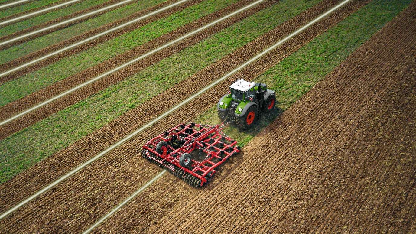 Um trator verde da Fendt com acessório para cultivo do solo aciona a linha de orientação tipo A-B