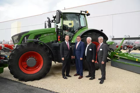 Vier Männer vor einem Fendt Traktor