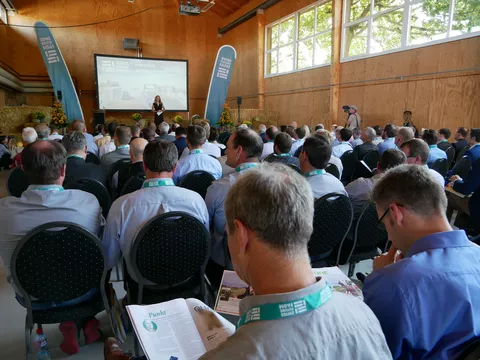 Besucher sitzen in einer Halle und schauen sich die Eröffnung der Swiss Future Farm an