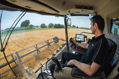 Landwirt in der Fahrerkabine mit dem neuen Lenksystem IDEALdrive