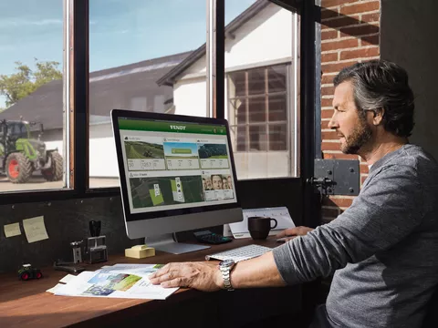 Landwirt sitzt vor dem Computer