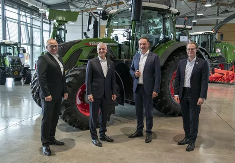 Vier Männer vor einem Fendt Traktor