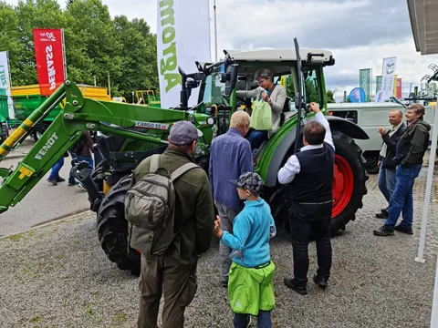 Besucher der Landwirtschaftsmesse betrachten den Fendt 211 Vario