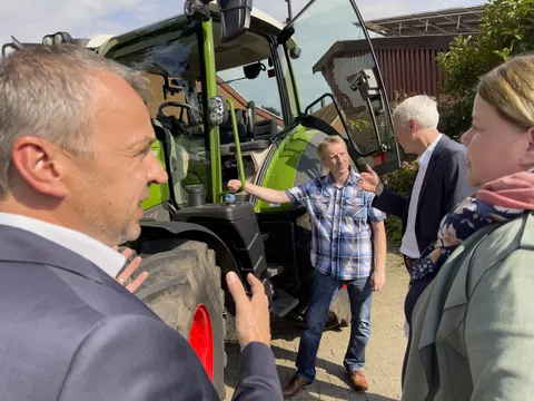 Vier Personen im Gespräch vor dem Fendt 314 Vario Traktor