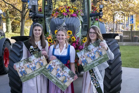 Drei Hoheiten mit Kalender vor einem Fendt Traktor mit Blumenschmuck