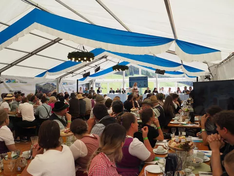 Zahlreiche Menschen sitzen in einem Festzelt