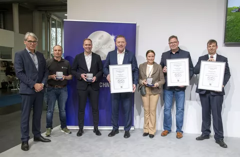 Mehrere Personen stehen mit Urkunden für ein Gruppenbild zusammen