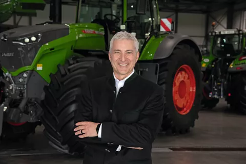 Portrait von Eric Hansotia, CEO AGCO Corporation im Anzug vor einem Fendt Traktor