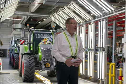 Christoph Gröblinghoff, Vorsitzender der Fendt Geschäftsführung, steht vor dem mit Blumen geschmückten Fendt 728 Vario am Lichttunnel in Marktoberdorf