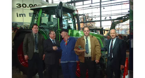 5 Männer vor einem Fendt Farmer 412 Vario bei der Auslieferung des 30.000sten Fendt Schleppers an die Niederlanden im Jahr 2013, der dritte Mann von links mit niederländischer Tracht - blaue Kleidung, Schiebermütze und ein rotes Halstuch