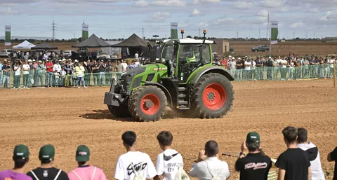 Fendt00 Vario bei einer Vorführung des Fendtgüinos Feldtages im Vorder- und Hintergrund Zushauer hintergrünen Sicherheitszäunen