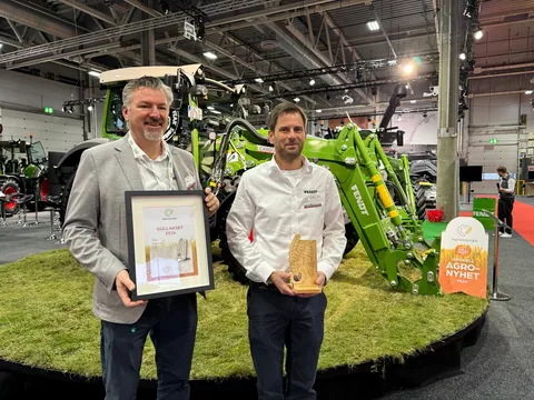 John Henrik Stadler (Business Manager Fendt Norwegen) und Jørgen Skjelin (Retail Manager Fendt Traktoren und Spritzen Norwegen) vor dem Fendt e100 Vario freuen sich über den Gullakset Award 2024 in Gold auf der norwegeischen Messe Agroteknikk