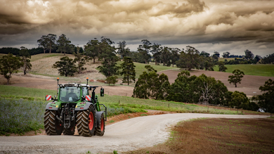 Ein Fendt 700 Vario Gen7 steht auf einer Straße in Australien. Im Hintergrund sind viele Bäume zu sehen.