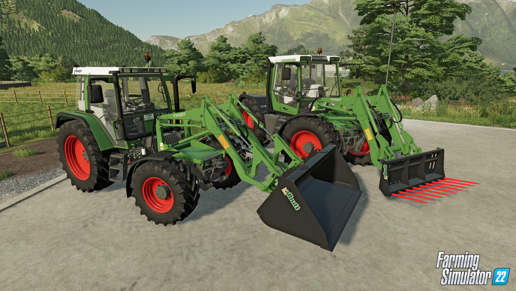 Ein Screenshot aus dem neuen Landwirtschafts-Simulator zeigt zwei alten Fendt Traktoren, inklusive einem Fendt Geräteträger auf einem Hof vor Bergen