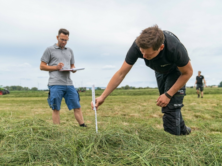 Zwei Männer stehen auf einem Feld und vermessen die Testschwaden