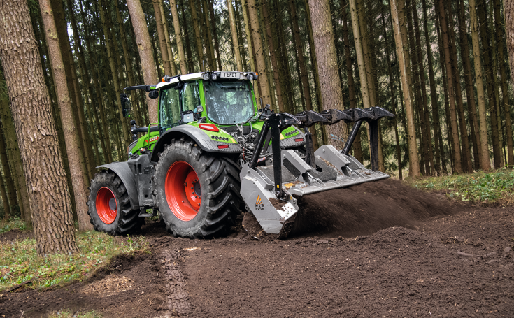 In einem Nadelwald arbeitet ein Fendt 700 Vario Gen7 mit einer Fräse am Heck