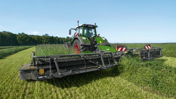 Aufnahme eines Fendt Slicer Heckmähwerks von hinten auf einer grünen Wiese.