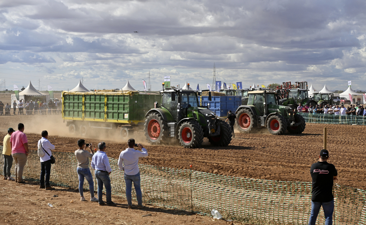 Ein Fendt 728 Vario und einer Fendt 930 Vario treten bei einem Rennen mit Anhängern gegeneinander an, im Vorder- und Hintergrund Zuschauer