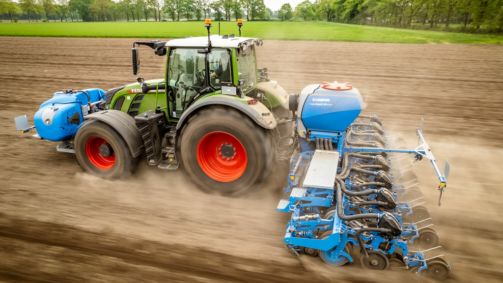 Ein grüner Fendt Traktor mit Anbaugerät im Feldeinsatz