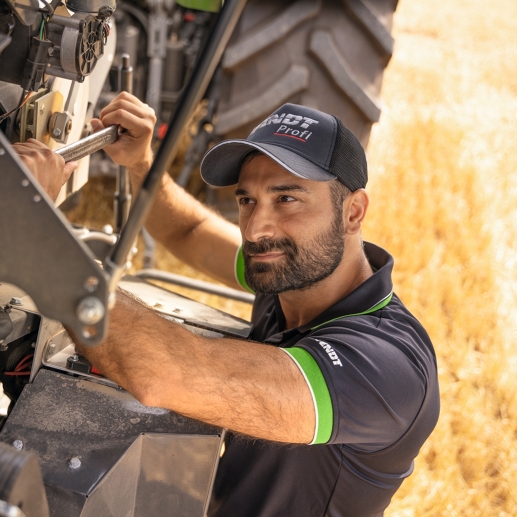 Fendt -servicemedarbejder ved montering af reservedele direkte i marken.