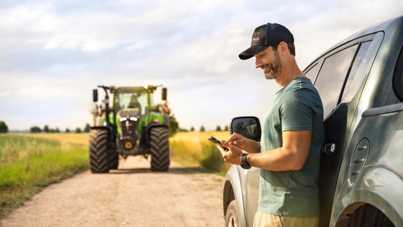 En landmand ser nyheder på sin mobiltelefon i MY AGCO App'en