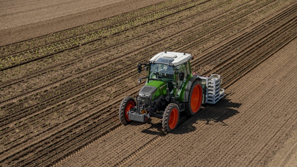 En Fendt e100 Vario kører i en mark og bearbejder jorden