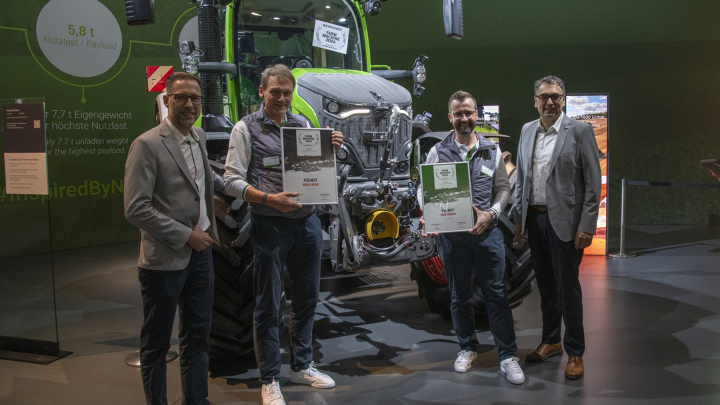 Fendt 600 Vario seisab põllul ja tõstab silopallid esilaaduriga üles.