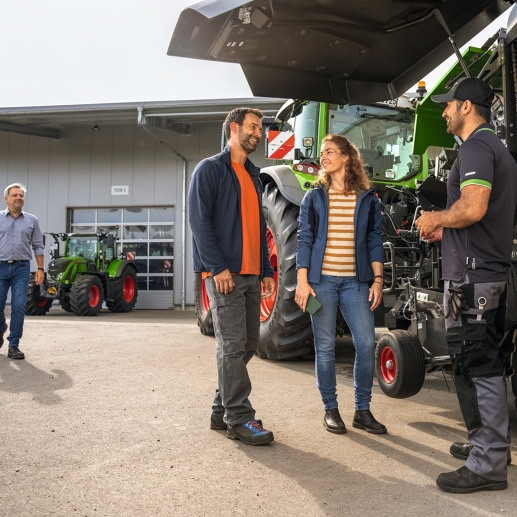 Una pareja de agricultores recibiendo su máquina reparada de su distribuidor Fendt