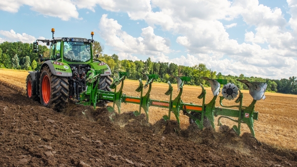 Un agricultor conduce un Fendt 700 Vario Gen6 con un arado Amazone mientras ara el campo.